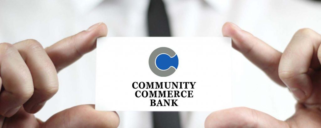 someone holding a community commerce bank business card